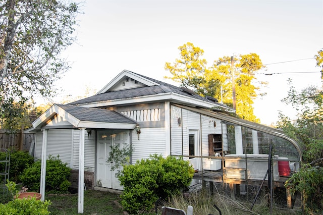 view of side of property with a shingled roof