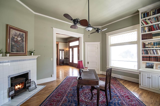 dining space with a wood stove, light hardwood / wood-style flooring, and a healthy amount of sunlight