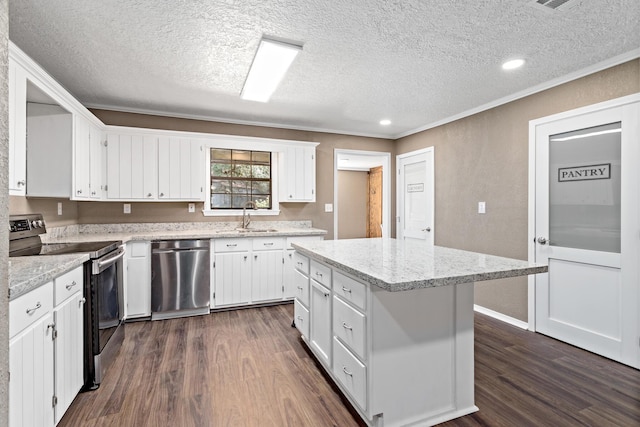 kitchen featuring white cabinets, sink, appliances with stainless steel finishes, a kitchen island, and dark hardwood / wood-style flooring