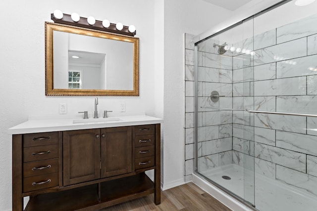 bathroom with walk in shower, vanity, and hardwood / wood-style flooring