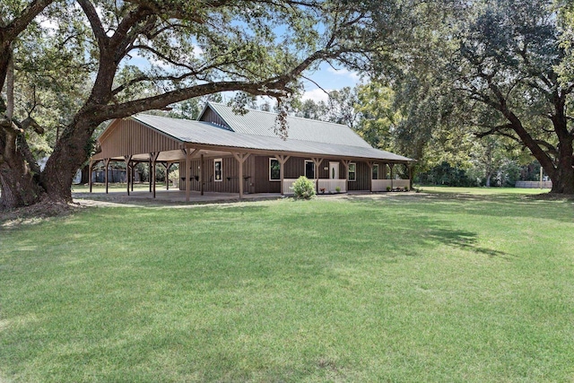 back of property featuring a carport and a lawn