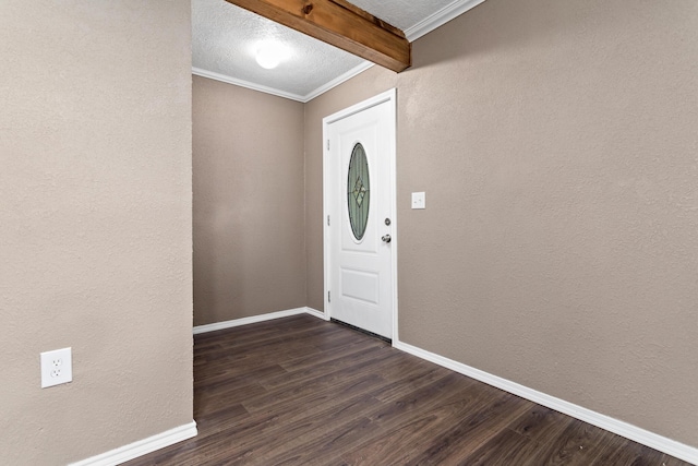 foyer entrance featuring beam ceiling, dark hardwood / wood-style flooring, a textured ceiling, and ornamental molding