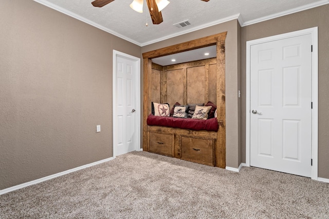 carpeted bedroom featuring a textured ceiling, ceiling fan, and ornamental molding