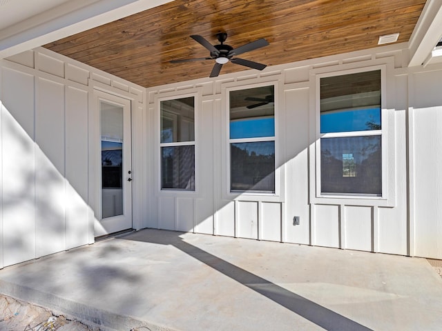 exterior space featuring a patio area, a ceiling fan, and board and batten siding