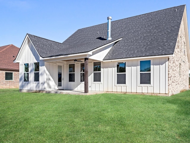 back of house featuring a lawn, board and batten siding, and a shingled roof