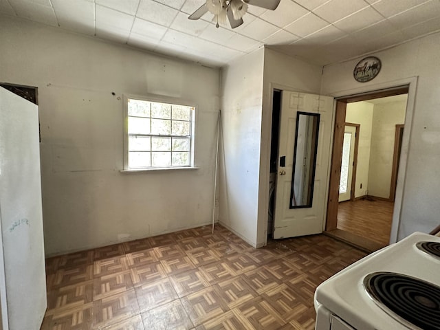 interior space featuring ceiling fan, dark parquet floors, and white stove