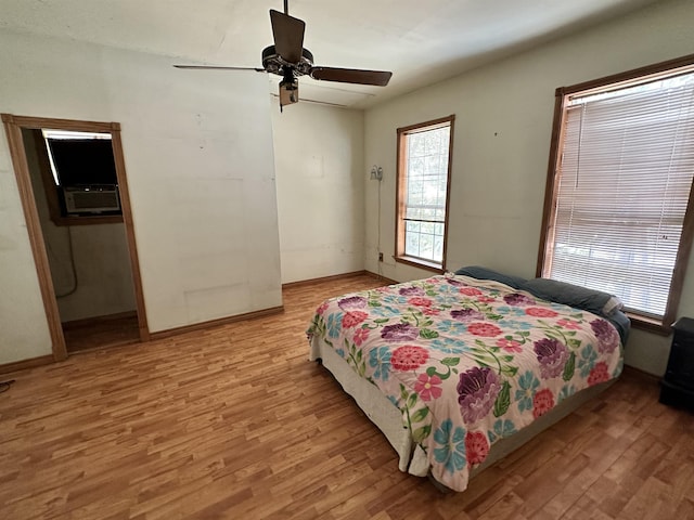 bedroom with ceiling fan, light hardwood / wood-style floors, and cooling unit