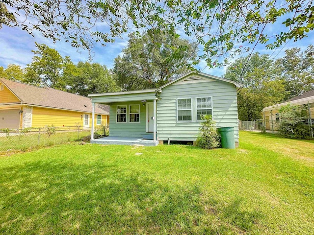 rear view of property featuring a lawn