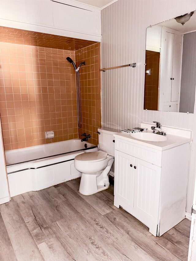 full bathroom featuring hardwood / wood-style floors, tiled shower / bath combo, toilet, and vanity