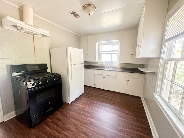 kitchen featuring black gas range oven, sink, exhaust hood, white refrigerator, and white cabinets