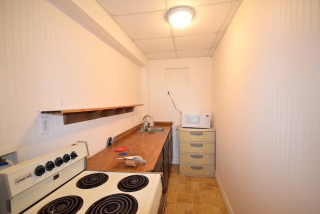 kitchen with wood counters, white appliances, a paneled ceiling, and sink