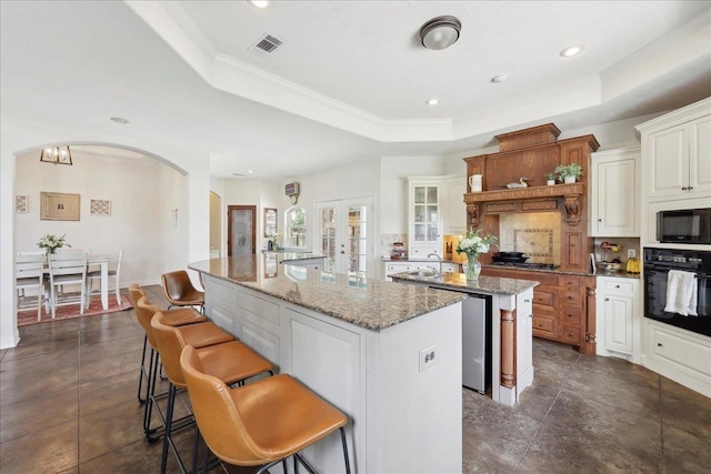 8185 Dawn Dr, Beaumont, TX 77705 - kitchen featuring a kitchen island with sink, oven, a raised ceiling, a breakfast bar, and a sink