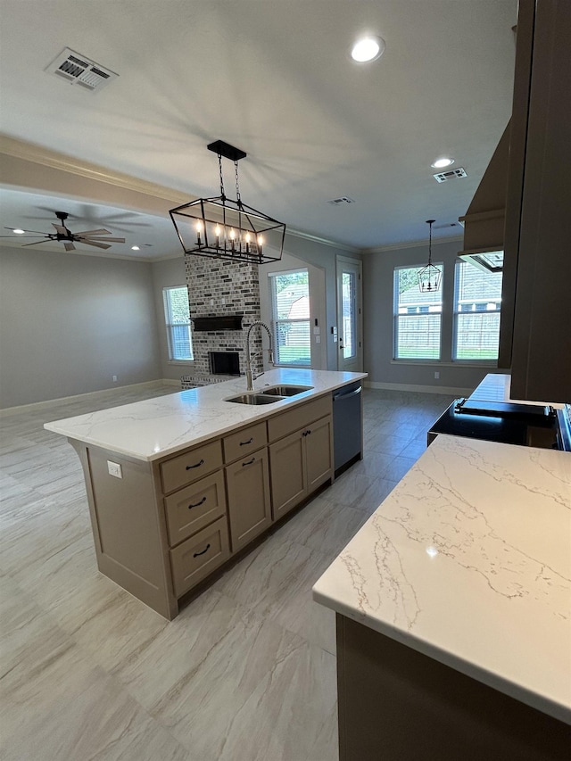 kitchen featuring a kitchen island with sink, crown molding, sink, stainless steel dishwasher, and light stone countertops