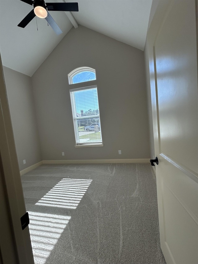 empty room featuring ceiling fan, light colored carpet, and lofted ceiling with beams