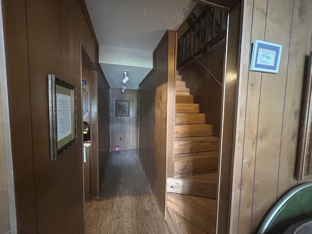104 Hornbeam Dr, Village Mills, TX 77663 - hallway with wooden walls, wood finished floors, a textured ceiling, and stairs