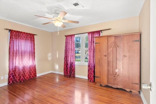 empty room with ceiling fan and hardwood / wood-style flooring