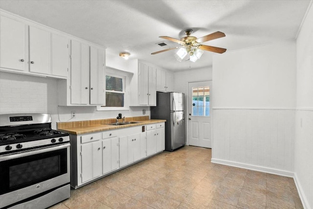 kitchen featuring ceiling fan, sink, white cabinets, and stainless steel appliances