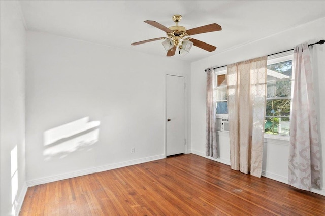 unfurnished room with ceiling fan, plenty of natural light, and hardwood / wood-style flooring