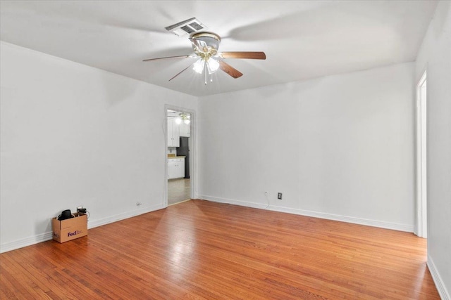 empty room with ceiling fan and light hardwood / wood-style floors