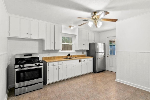 kitchen with ceiling fan, sink, white cabinetry, and stainless steel appliances