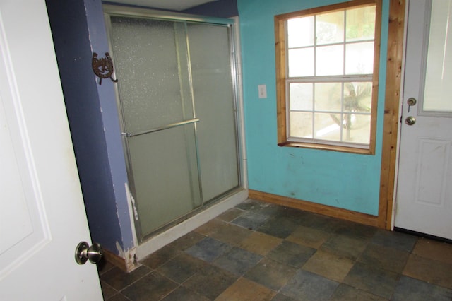 2114 11th St, Port Neches, TX 77651 - bathroom with stone finish flooring, a stall shower, baseboards, and healthy amount of natural light