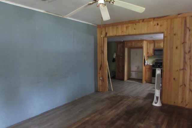 2114 11th St, Port Neches, TX 77651 - empty room featuring wood finished floors, ceiling fan, and wood walls