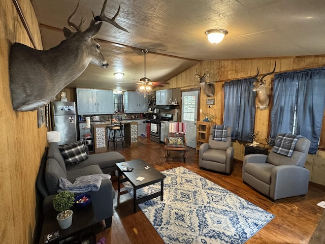 living room featuring ceiling fan, dark hardwood / wood-style flooring, and lofted ceiling