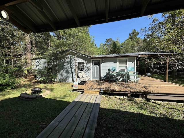 exterior space featuring a yard, an outdoor fire pit, and a wooden deck