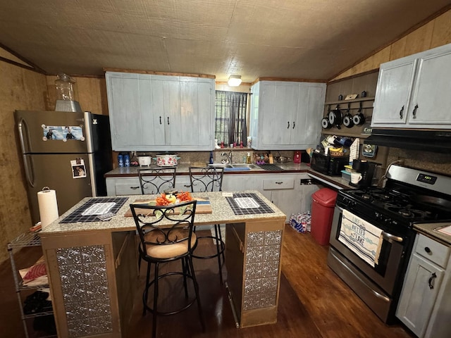 kitchen featuring white cabinets, dark hardwood / wood-style floors, range hood, a kitchen island, and stainless steel appliances