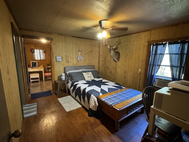 bedroom featuring ceiling fan, cooling unit, and wooden walls