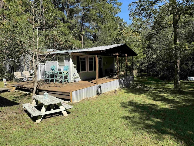 rear view of house with a lawn and a wooden deck