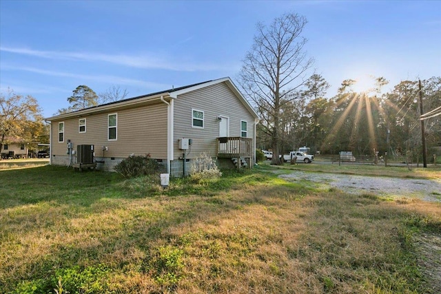 view of side of home featuring central air condition unit and a lawn