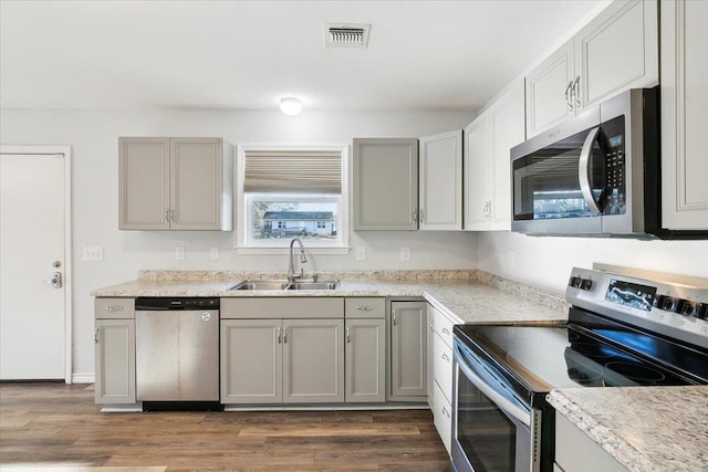 kitchen with sink, stainless steel appliances, dark hardwood / wood-style flooring, and gray cabinets