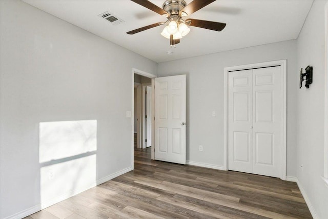 unfurnished bedroom with a closet, ceiling fan, and hardwood / wood-style floors