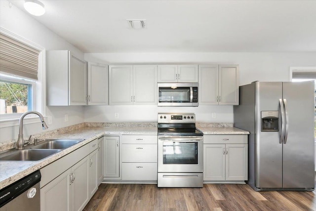 kitchen featuring sink, appliances with stainless steel finishes, and dark wood-type flooring