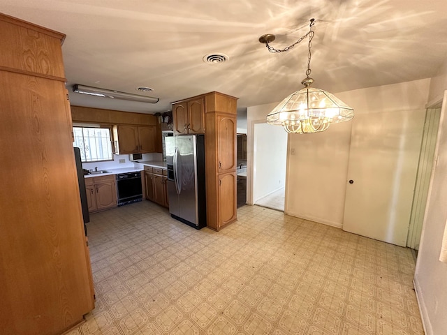 kitchen featuring pendant lighting, dishwasher, sink, stainless steel refrigerator with ice dispenser, and a chandelier