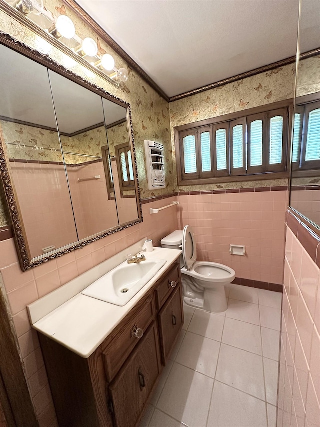 bathroom with tile patterned flooring, heating unit, vanity, tile walls, and ornamental molding