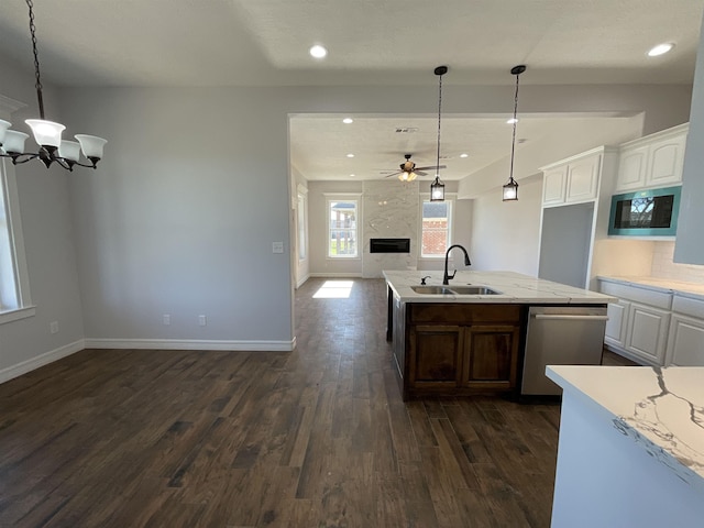 kitchen featuring a kitchen island with sink, sink, pendant lighting, dishwasher, and white cabinetry