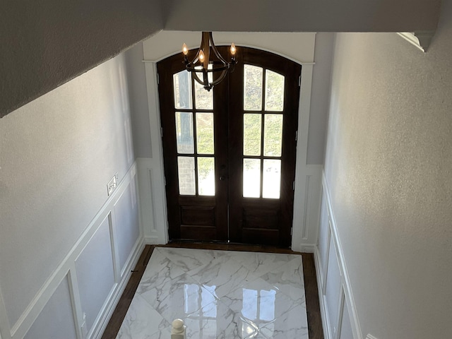 doorway featuring a chandelier and french doors