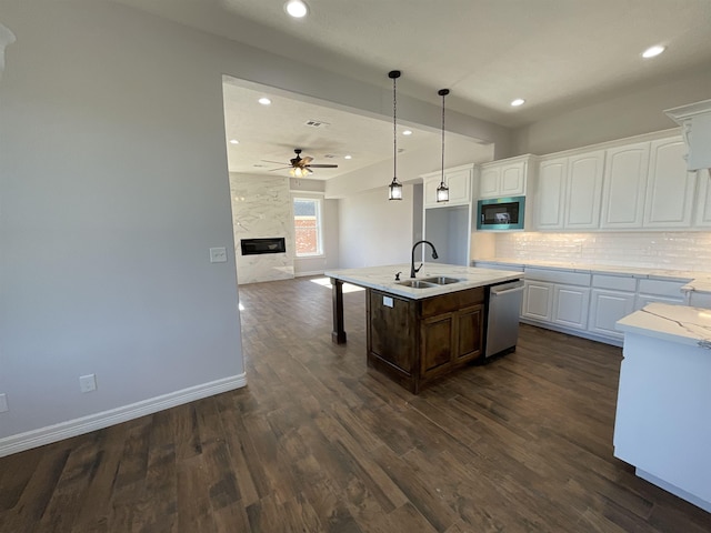 kitchen with backsplash, stainless steel dishwasher, built in microwave, sink, and white cabinetry