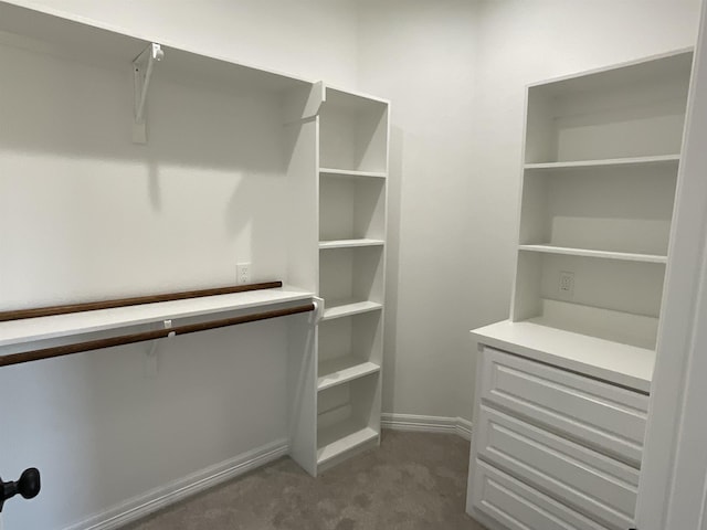 walk in closet featuring dark colored carpet