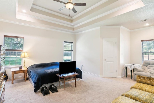 bedroom featuring a raised ceiling, ceiling fan, light colored carpet, and ornamental molding