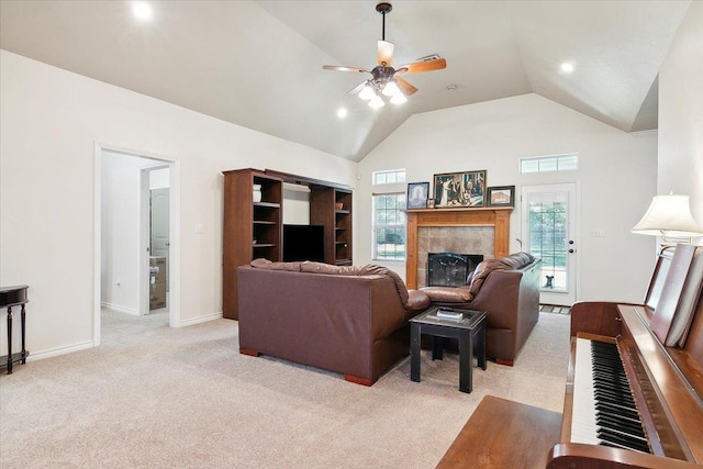 carpeted living room with high vaulted ceiling, ceiling fan, and a tiled fireplace