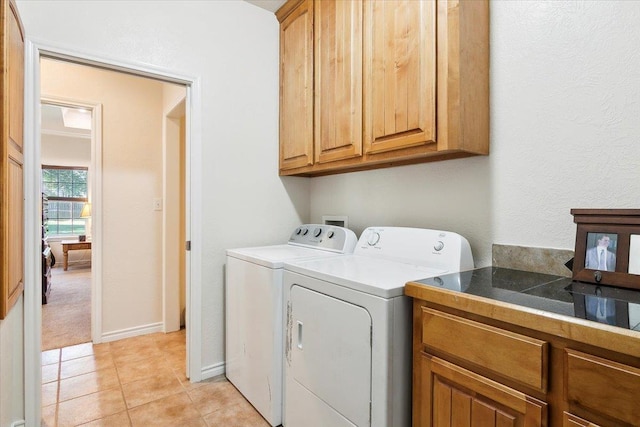 laundry room with cabinets, separate washer and dryer, and light tile patterned floors