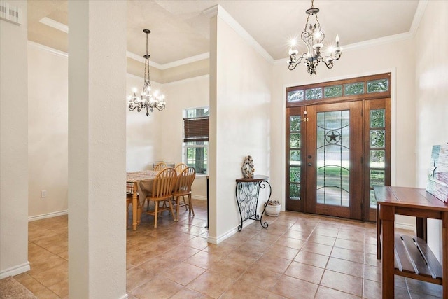 tiled entryway with ornamental molding and an inviting chandelier