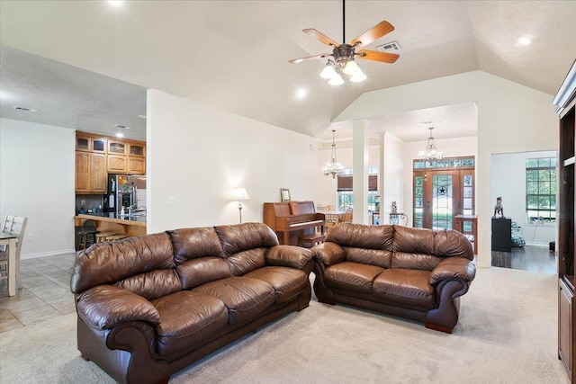 living room featuring light tile patterned floors, ceiling fan with notable chandelier, and lofted ceiling