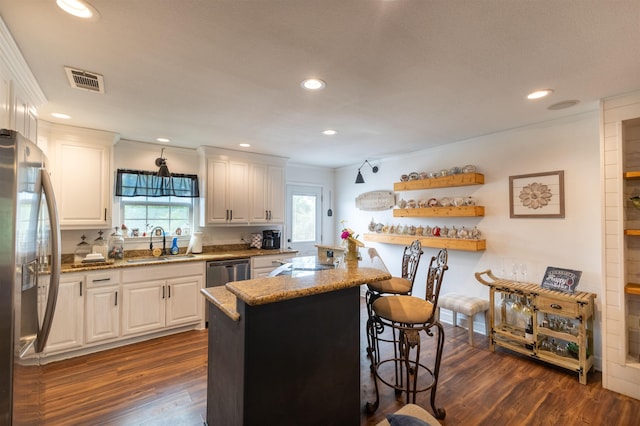 2315 Granger Dr, Bridge City, TX 77611 - kitchen featuring a sink, stainless steel appliances, white cabinets, light stone countertops, and dark wood-style floors