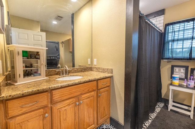 2315 Granger Dr, Bridge City, TX 77611 - bathroom with stacked washer / drying machine, vanity, a textured wall, and curtained shower
