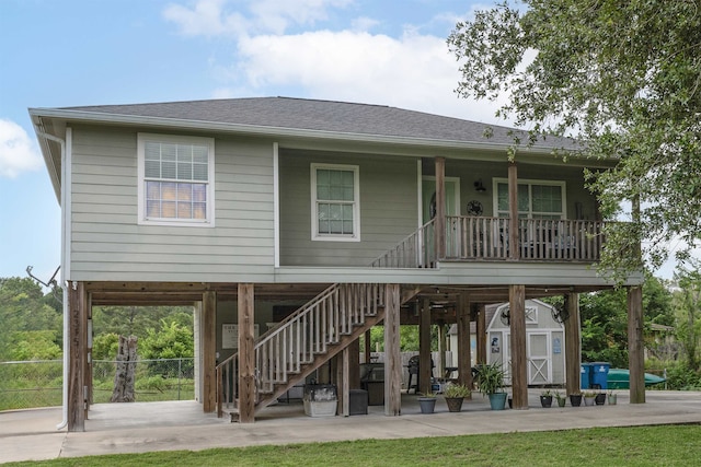 2315 Granger Dr, Bridge City, TX 77611 - rear view of house featuring stairs, a shingled roof, a porch, and a patio area
