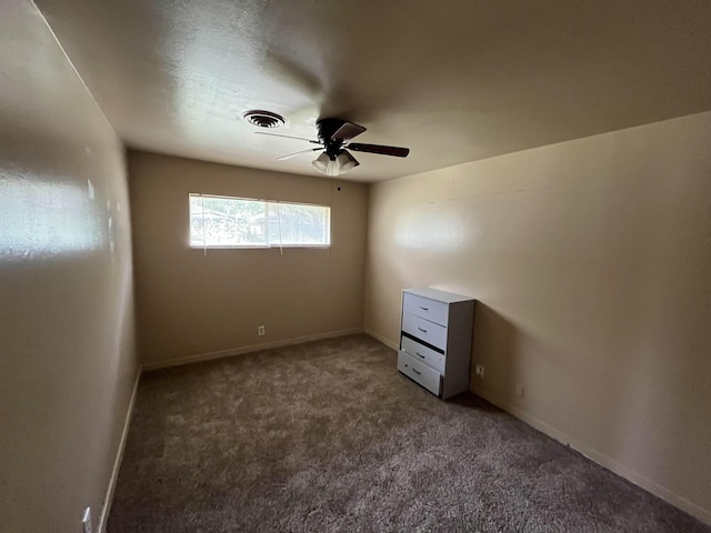 spare room with ceiling fan and dark carpet